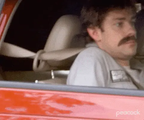 The Office Gif bei dem sich eine Person im Auto versteckt, indem man den Sitz nach hinten schiebt.